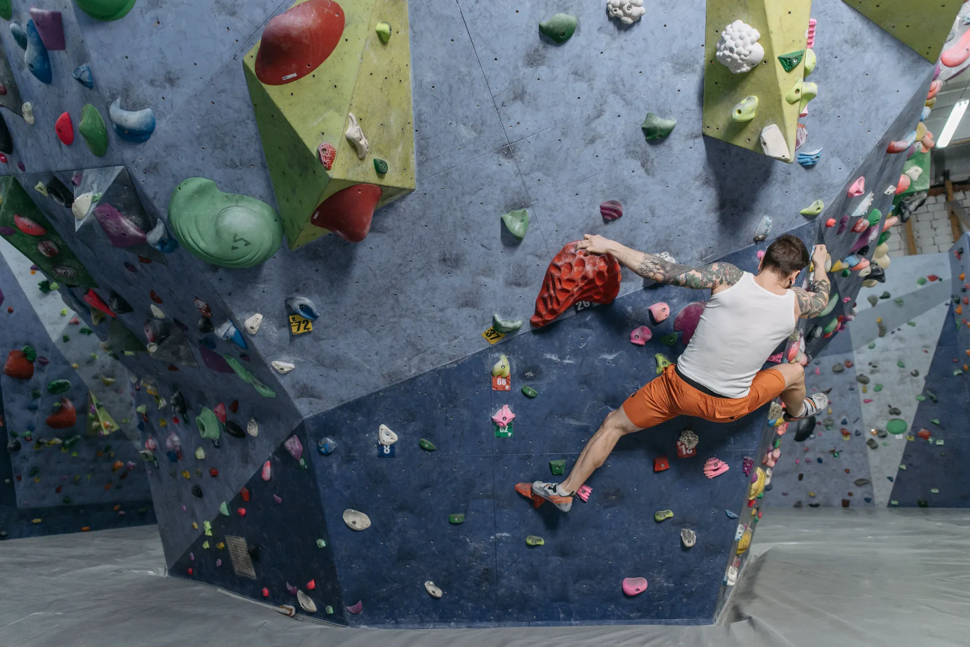A boulderer working a problem on an indoor wall