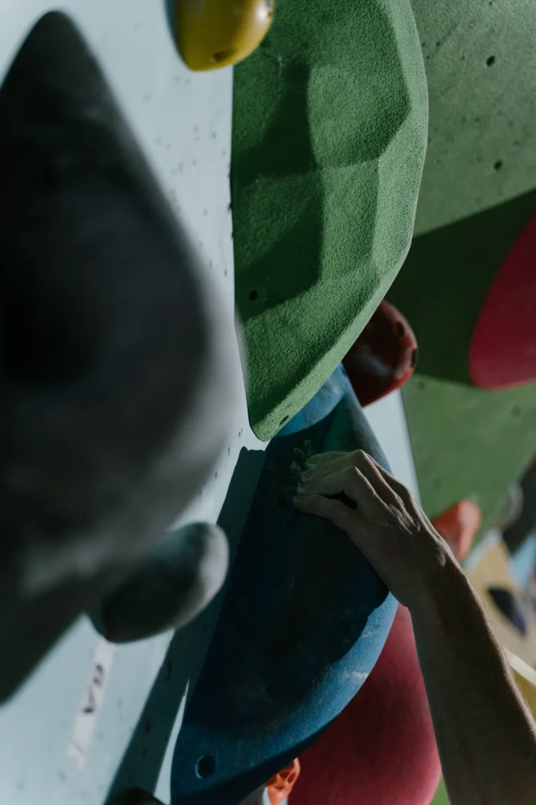 A climber's hand on a bouldering wall, seen through the Dyno Club camera viewfinder